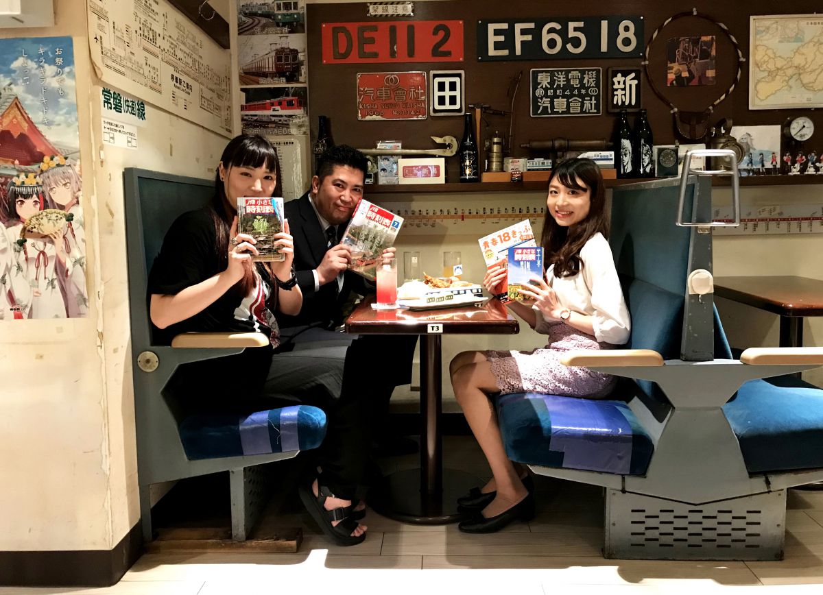 大内編集長と蜂谷は、愛用のJTB時刻表で小顔効果を狙ってます